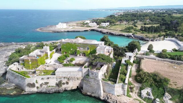 Porto Ghiacciolo and Santo Stefano Abbey, Monopoli, Puglia, Italy. Aerial drone footage of the historic coastal abbey, turquoise Adriatic Sea and rocky shoreline on a sunny summer day.