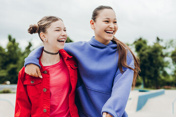 Cheerful teenage girls sharing laughter and friendship during an outdoor gathering