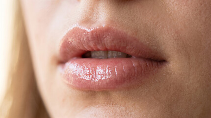 Naklejka premium Lips with a glossy pink finish express a natural and healthy appearance for beauty advertising campaigns.