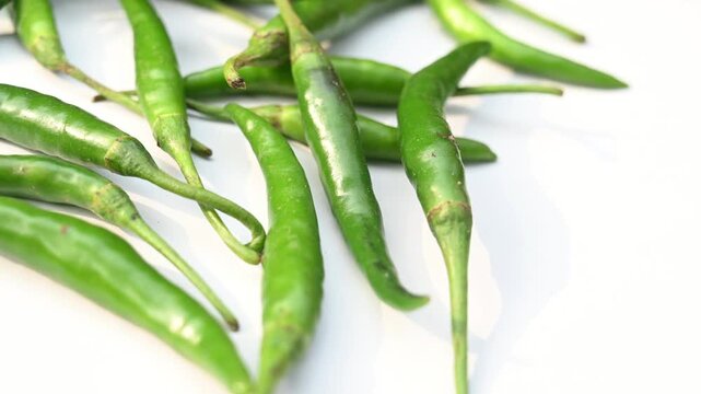 Green chilli peppers are a popular, pungent Indian chilli known for their spicy flavor, vibrant dark green color, and elongated shape. Green chilli pepper plant pests, aphid colony. hoverfly rest.