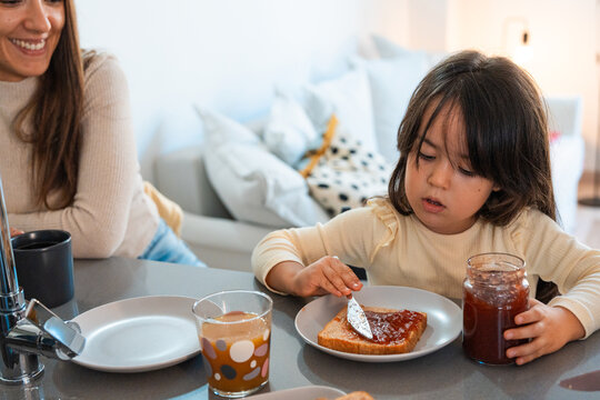 Young daughter having breakfast with her mother