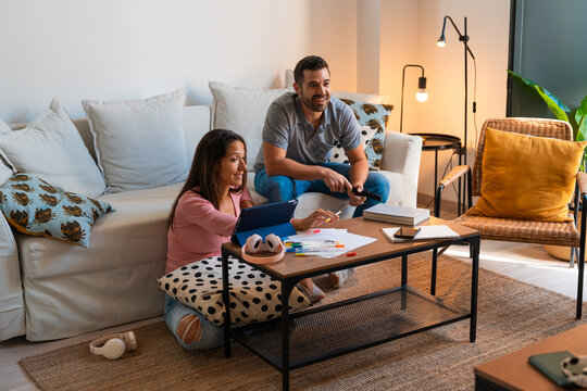 Couple distracted watching television in the living room