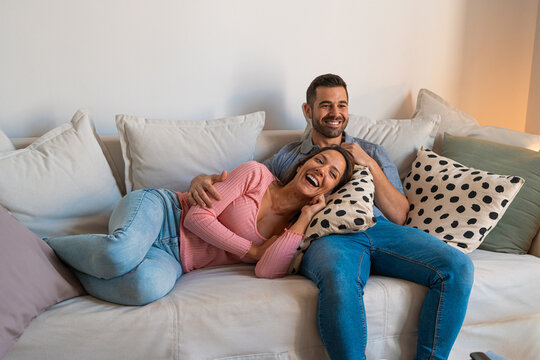 Couple lying on the sofa watching tv