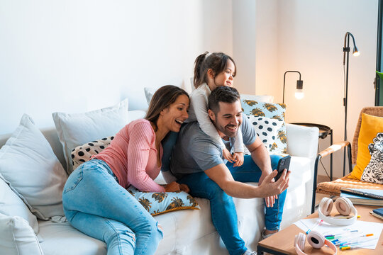 Happy family taking a selfie together in the living room