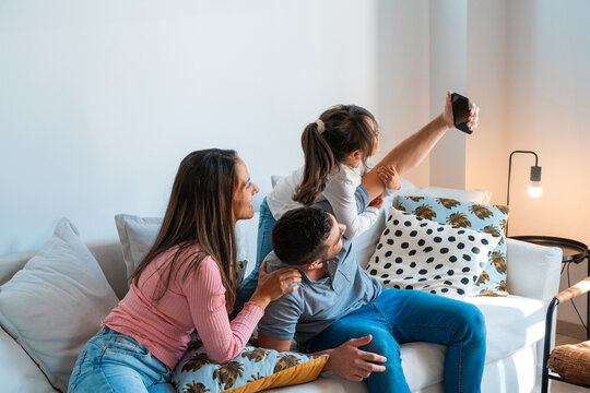 Family of three taking a selfie together at home