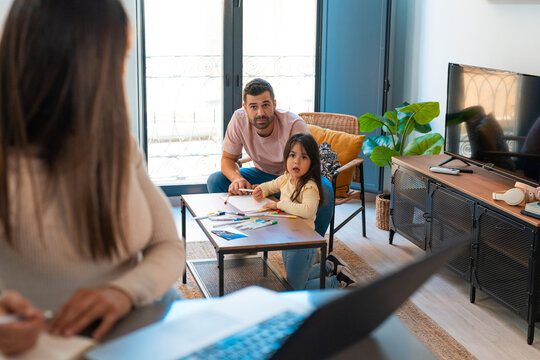 Woman working from home next to her family