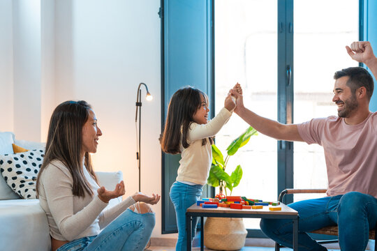 Girl giving high five to father after winning jenga game