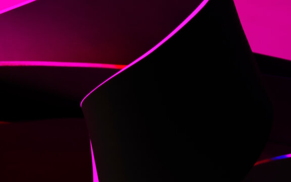 Geometric shapes illuminated by pink light, abstract dark background, studio shot photo