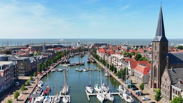 Aerial flight over a historic harbor town on a beautiful summer day in Europe