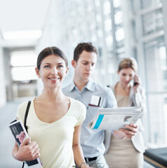 Obraz premium Happy, woman and wait in airport with travel holiday, magazine or queue for boarding overseas flight. Person, smile and people line up in terminal for international vacation, trip and departure.