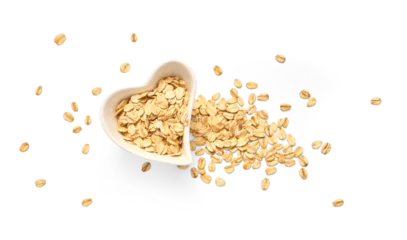 A heart-shaped white bowl brimming with rolled oats, with additional oat flakes artfully scattered around on a clean white background © Tatyana Sidyukova