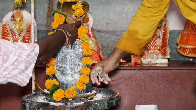 Devotee Performing Sacred Shiva Puja with Decorated Lingam and Naga Idol