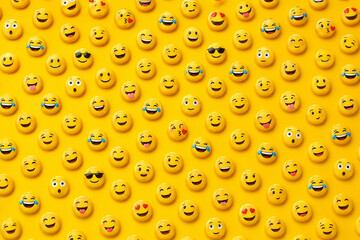 Seamless pattern of colorful 3D emoji faces on vibrant yellow background, playful social media texture and cheerful wallpaper