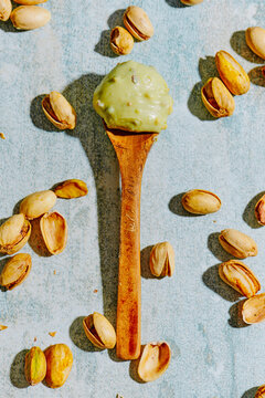 a scoop of pistachio cream on a wooden spoon