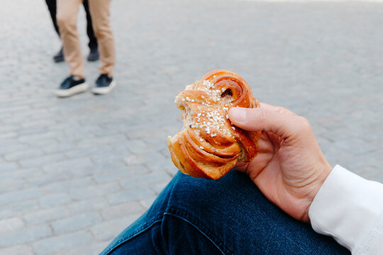 a man enjoys a kanelbulle in Stockholm