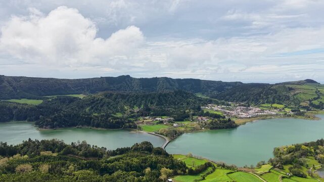 An aerial wide panorama shot of the iconic Lagoa das Sete Cidades twin lakes divided by a bridge in image d0321d jpg nestled inside a massive volcanic caldera on Sao Miguel Island Azores Portugal