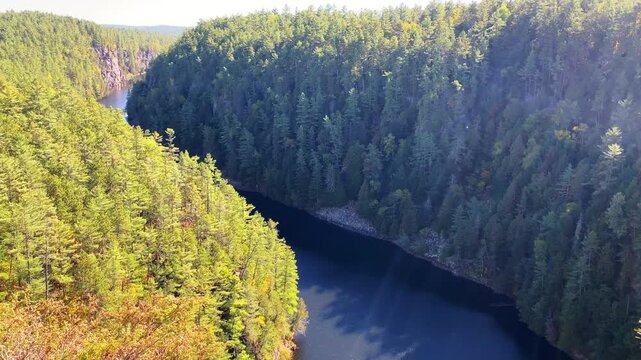 Medium view of Barron Canyon in Algonquin Park, with sun flares lighting the rugged landscape and revealing the canyon depth below.