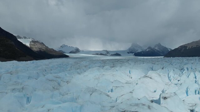 Perito Moreno Glacier extends from the Southern Patagonian Ice Field beneath the Patagonian Andes in Los Glaciares National Park, Santa Cruz, Argentina, drone pullback shot.