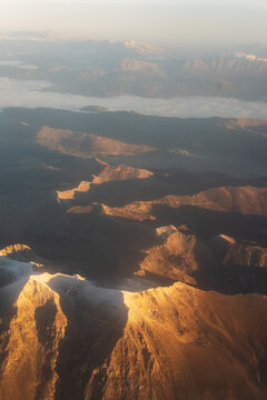 Snow-Capped Mountain Peaks at Sunrise with the Danube River in the Distance