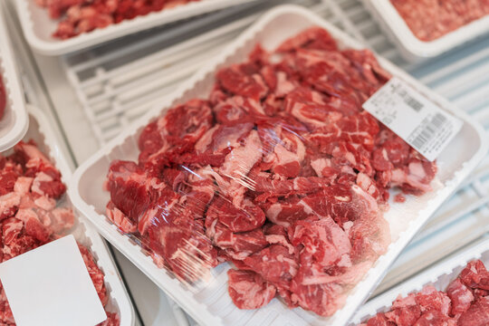 packaged fresh raw beef chunks displayed in supermarket freezer