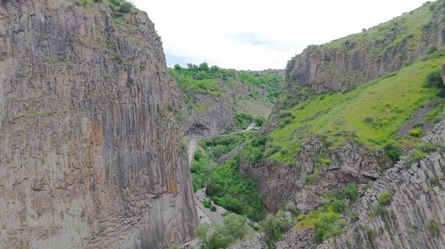 Symphony of the Stones in Garni Gorge, Armenia. Spectacular natural basalt rock columns with hexagonal volcanic formations along the Azat River beneath the ancient Garni Temple. Stunning geological la