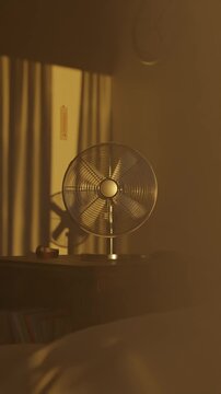 Rotating electric fan in the evening sunlight. Concept heatwave