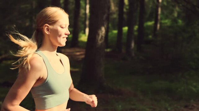 Blonde runner n pine forest trail under sunlight showing outdoor endurance activity healthy lifestyle and natural energy movement through green woodland