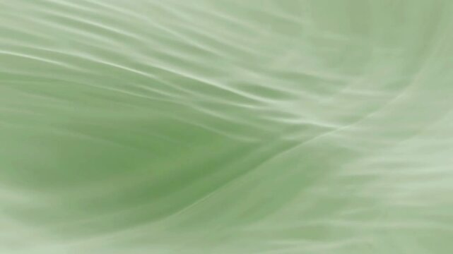 Soft green water ripples and waves flowing in a smooth motion
