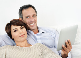 Fototapeta premium Portrait, relax or happy couple with tablet on sofa for entertainment or online subscription in home. Man, woman or smile with technology on couch for streaming service or network connection in house
