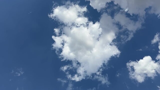 Timelapse video of blue sky with drifting white clouds, nature scene with calm motion and clear atmosphere