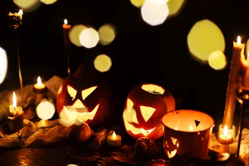 Happy Halloween. Carved glowing halloween pumpkins, burning candles and spooky spiders in dark. Atmospheric halloween night with jack o lantern decorations. Boo. holiday banner © sonyachny