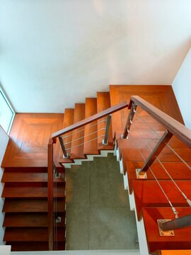 High angle perspective of modern wooden staircase with steel cable balustrade.