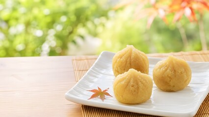 秋の和菓子 栗きんとん（茶巾絞り）と色づき始めたもみじの葉