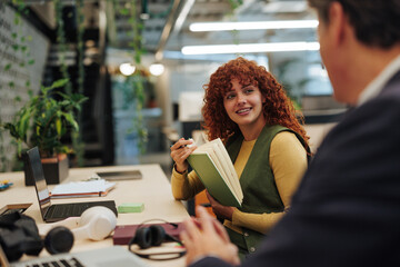 Young woman collaborating with colleague in office meeting
