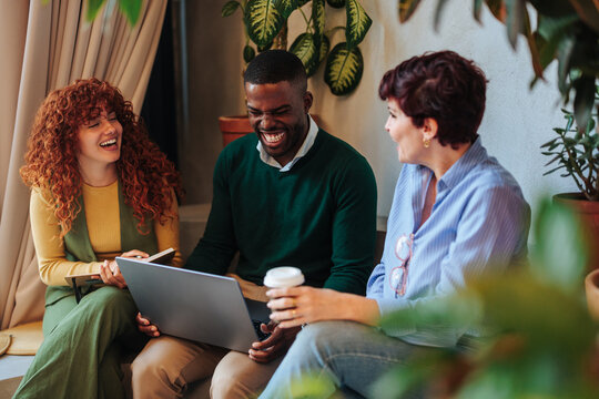 Diverse team friends laughing during casual discussion