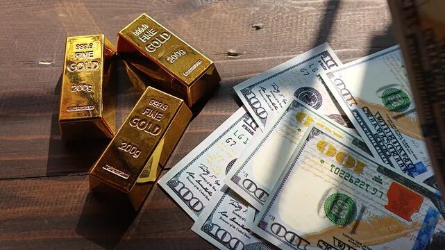 Gold bars and US dollar banknotes on wooden table with sunlight, symbolizing wealth, investment, finance, savings, and safe assets.