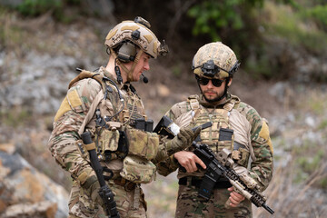 Senior military soldier army force is showing safety gun instruction during field operation in...