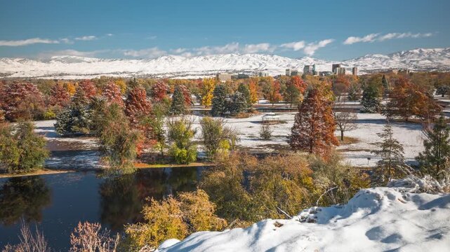 Ann Morrison Park Winter Aerial View with Snowy Ground and Vibrant Fall Foliage Under Clear Blue Sky in 4k Drone Shot Capturing the Scenic Transition of Seasons in an Urban Landscape