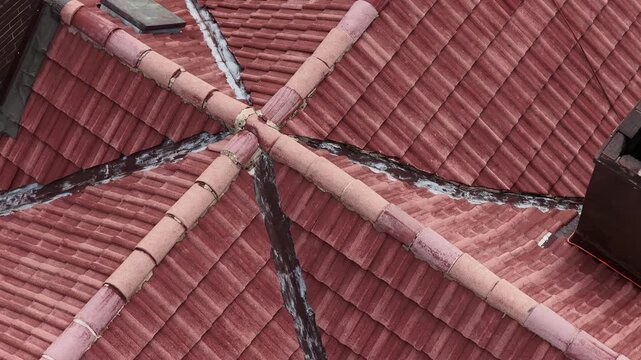 Roof with roof tiles cleaned by pressure washing, showing freshly washed surface prepared for painting, residential building rooftop maintenance with detailed texture and restoration process.