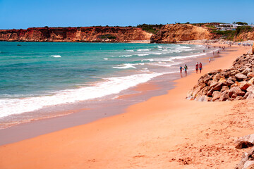 People walk along La Fontanilla beach on sunny day, Costa de la Luz, Spain. © Tomasz