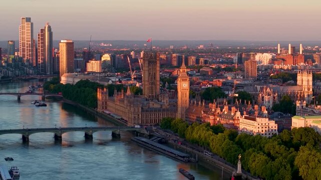 Aerial view of the Westminster Palace, Bridge and Big Ben clocktower in London, England, during a golden summer sunrise