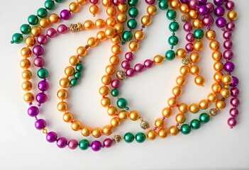 Fototapeta premium Colorful mardi gras bead necklaces flat lay on white background