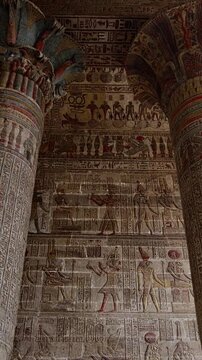 The temple of Esna, dedicated to the god Khnum. Egypt. Esna temple hypostyle hall with massive painted columns and colorful hieroglyphic reliefs on ceiling in Egypt, ancient Roman-era architecture wit