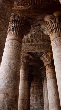 The temple of Esna, dedicated to the god Khnum. Egypt. Esna temple hypostyle hall with massive painted columns and colorful hieroglyphic reliefs on ceiling in Egypt, ancient Roman-era architecture wit