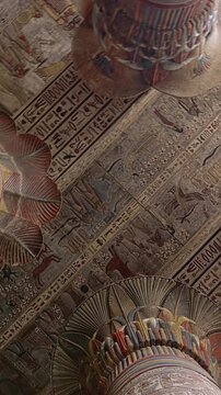 The temple of Esna, dedicated to the god Khnum. Egypt. Esna temple hypostyle hall with massive painted columns and colorful hieroglyphic reliefs on ceiling in Egypt, ancient Roman-era architecture wit