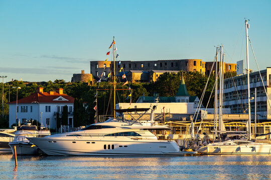 Borgholm, Sweden A yacht in the harbour at sunset and the Borgholms Slott or Borgholm Castle.