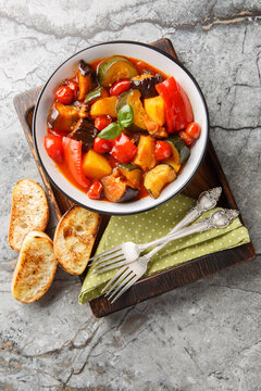 Ciambotta or giambotta is a summer vegetable stew of southern Italian cuisine closeup on the plate on the table. Vertical top view from above