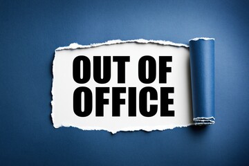 Naklejka premium Out of office phrase written on white paper under torn blue background