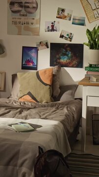 Vertical no people shot of empty teen bedroom showing unmade bed, school backpack, and textbooks on desk. Clip is ideal for student housing ads or back-to-school marketing campaigns