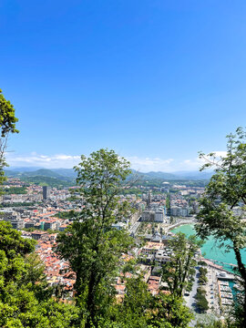 La Concha Bay panorama from Mount Urgull above sunny San Sebastian coastline and mountains, Spain